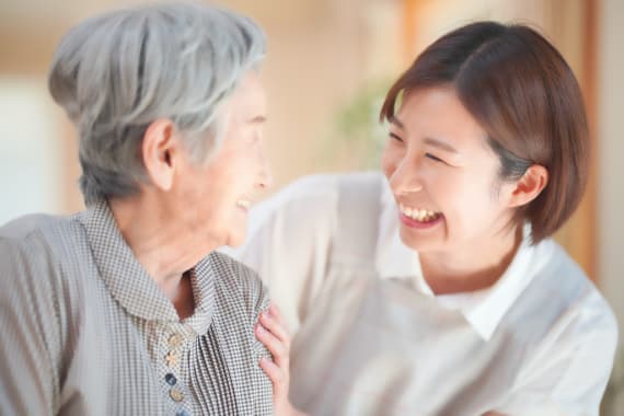 笑顔で話す高齢者と介助者